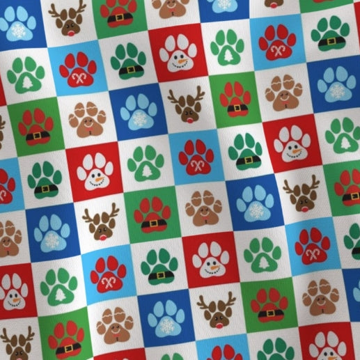 Patterned fabric with colorful paw prints and reindeer faces on a checkered background